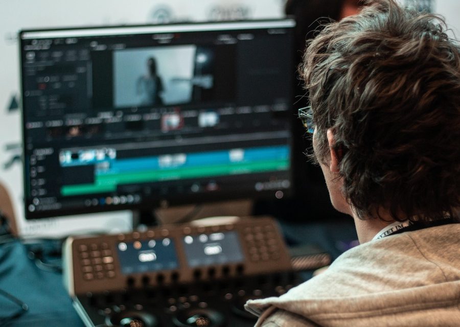 编辑部工作场景，编辑在木质长桌前对照屏幕整理兰香如故电视剧免费观看的剧集资料，桌角放着标注便签和一杯凉掉的红茶